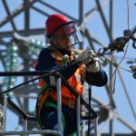 shallow focus photo of man fixing steel cable